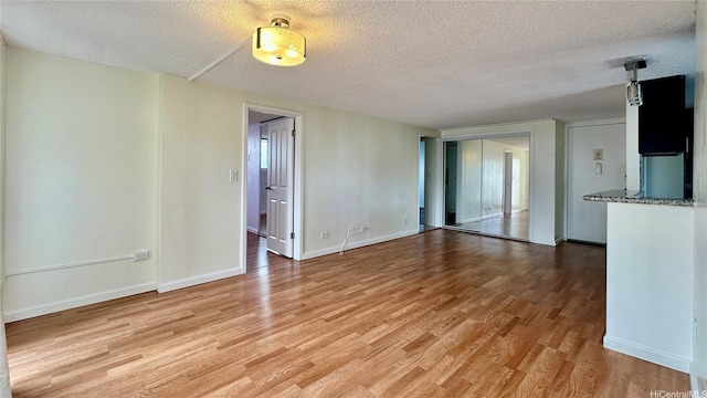 1121 Wilder Ave Unit 900B, Honolulu, HI 96822 - unfurnished living room featuring a textured ceiling and light wood finished floors