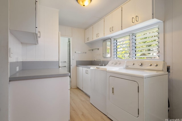 44 Akamu Pl, Honolulu, HI 96817 - laundry room featuring washer and dryer, cabinet space, and light wood-style flooring