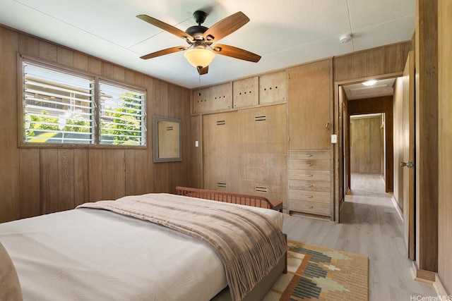 44 Akamu Pl, Honolulu, HI 96817 - bedroom featuring wooden walls, light wood-type flooring, and a ceiling fan
