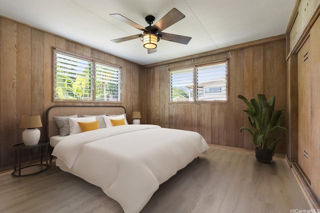 44 Akamu Pl, Honolulu, HI 96817 - bedroom featuring light wood finished floors, wooden walls, and a ceiling fan