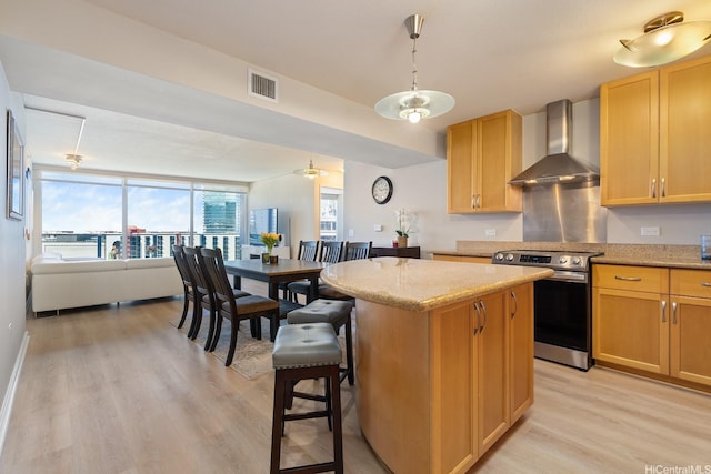 1288 Kapiolani Blvd Unit I-1506, Honolulu, HI 96814 - kitchen with wall chimney range hood, electric range, light wood-style floors, a kitchen island, and light stone countertops
