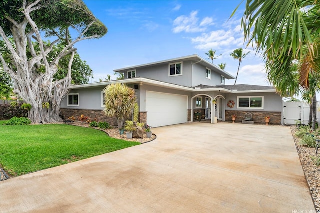 84-663 Upena St, Waianae, HI 96792 - traditional-style house with stone siding, stucco siding, a gate, concrete driveway, and an attached garage