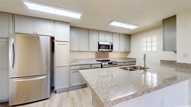 91-1201 Kaneana St Unit 3J, Ewa Beach, HI 96706 - kitchen featuring stainless steel appliances, a peninsula, light wood finished floors, a textured ceiling, and gray cabinets