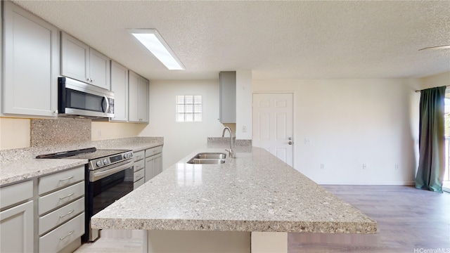 91-1201 Kaneana St Unit 3J, Ewa Beach, HI 96706 - kitchen with stainless steel appliances, a textured ceiling, light wood-style floors, and light stone countertops