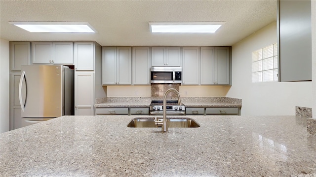 91-1201 Kaneana St Unit 3J, Ewa Beach, HI 96706 - kitchen with appliances with stainless steel finishes, light stone counters, a textured ceiling, and gray cabinets