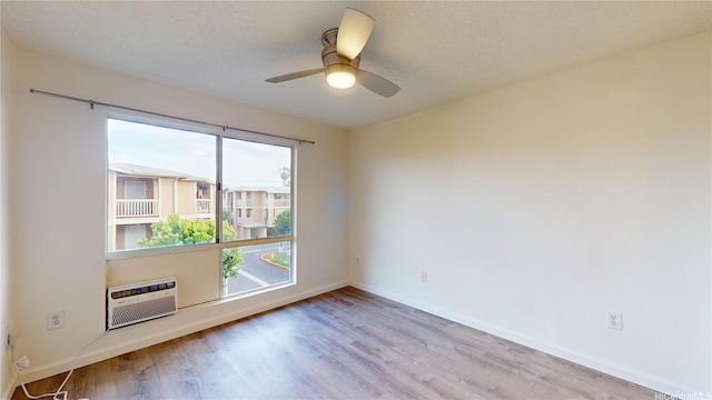 91-1201 Kaneana St Unit 3J, Ewa Beach, HI 96706 - empty room featuring wood finished floors, a wall unit AC, a ceiling fan, and a textured ceiling