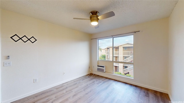 91-1201 Kaneana St Unit 3J, Ewa Beach, HI 96706 - spare room featuring wood finished floors, a ceiling fan, a textured ceiling, and a wall mounted AC