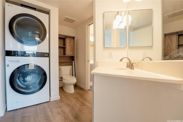 91-1201 Kaneana St Unit 3J, Ewa Beach, HI 96706 - laundry room featuring stacked washer / dryer and wood finished floors