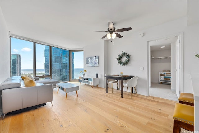 1001 Queen St Unit 2506, Honolulu, HI 96814 - living room featuring light wood-style floors, a ceiling fan, and a wall of windows
