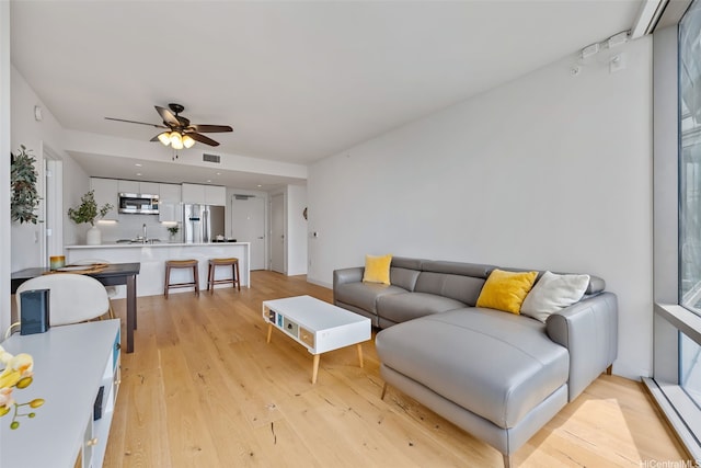1001 Queen St Unit 2506, Honolulu, HI 96814 - living room featuring ceiling fan and light wood-style floors