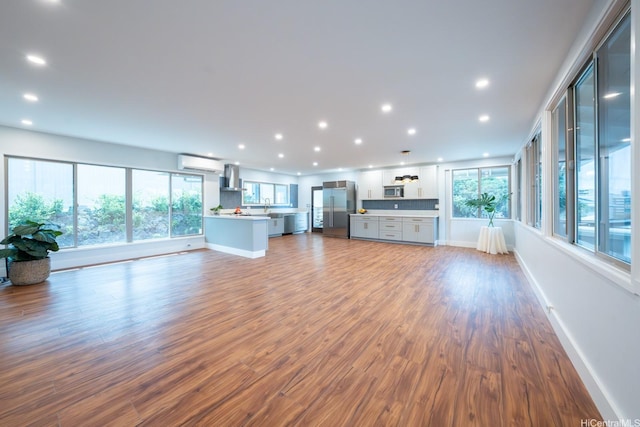1207 Lilo Pl, Honolulu, HI 96822 - unfurnished living room featuring a wall mounted air conditioner, wood finished floors, and recessed lighting