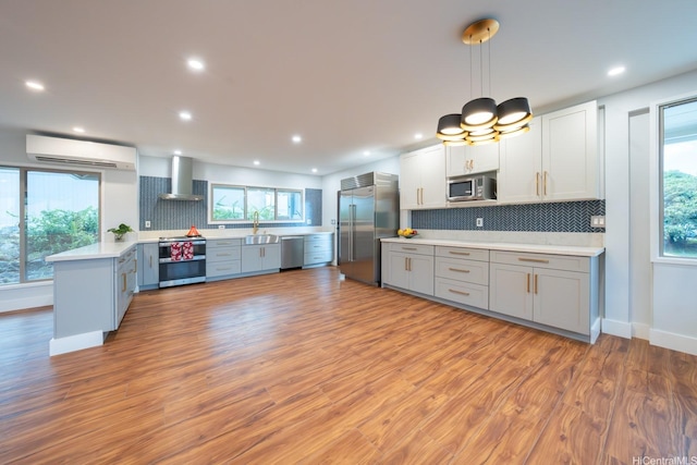 1207 Lilo Pl, Honolulu, HI 96822 - kitchen with appliances with stainless steel finishes, wall chimney exhaust hood, a wall mounted AC, light countertops, and tasteful backsplash