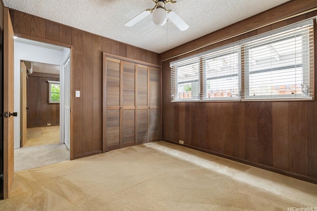 4722 Likini St, Honolulu, HI 96818 - unfurnished bedroom with carpet floors, multiple windows, a textured ceiling, a closet, and wood walls
