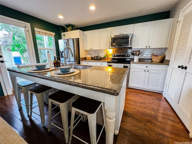 91-1356 Kaileolea Dr, Ewa Beach, HI 96706 - kitchen with appliances with stainless steel finishes, tasteful backsplash, white cabinetry, a center island with sink, and recessed lighting