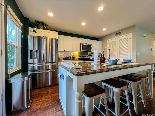 91-1356 Kaileolea Dr, Ewa Beach, HI 96706 - kitchen featuring appliances with stainless steel finishes, white cabinetry, dark wood-style flooring, recessed lighting, and a breakfast bar area