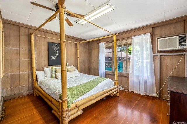 259 N Kalaheo Ave Unit A, Kailua, HI 96734 - bedroom featuring wood walls, a wall unit AC, wood finished floors, and a ceiling fan