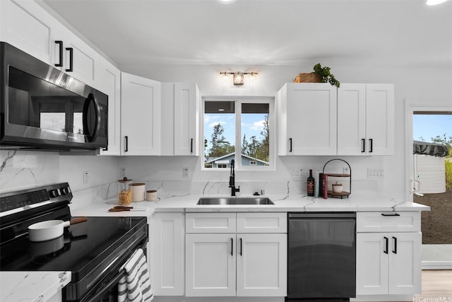 16-2073 Plumeria Dr, Pahoa, HI 96778 - kitchen with black range with electric stovetop, dishwashing machine, white cabinets, and light stone counters