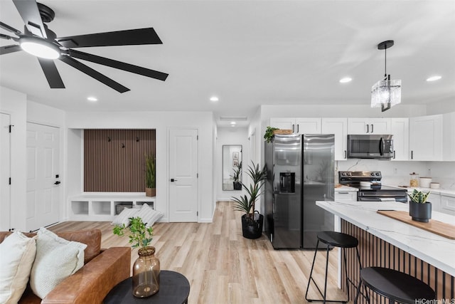 16-2073 Plumeria Dr, Pahoa, HI 96778 - kitchen with stainless steel appliances, light stone counters, a kitchen bar, white cabinetry, and recessed lighting
