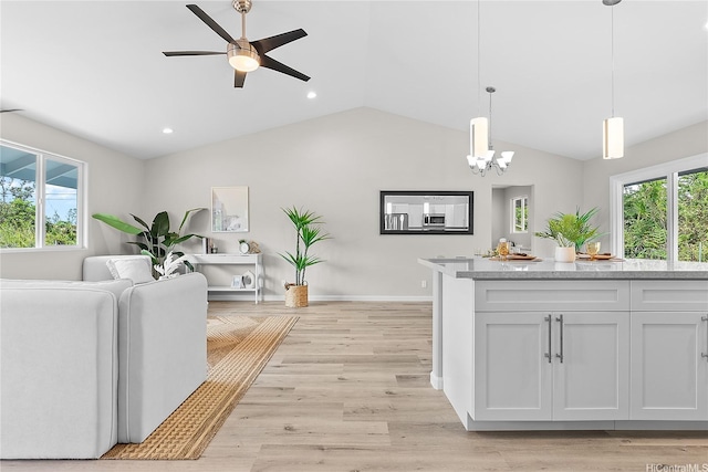 16-2154 Coral Dr, Pahoa, HI 96778 - kitchen with healthy amount of natural light, a chandelier, vaulted ceiling, white cabinets, and hanging light fixtures