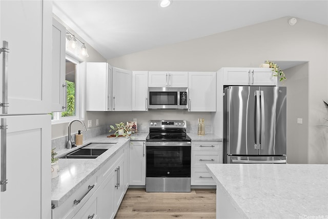 16-2154 Coral Dr, Pahoa, HI 96778 - kitchen with appliances with stainless steel finishes, vaulted ceiling, white cabinetry, light wood-style floors, and light stone counters
