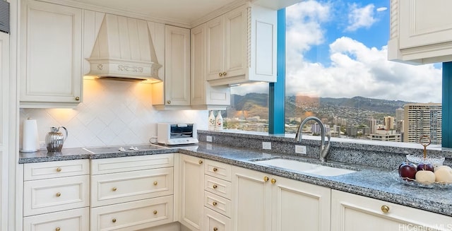 1888 Kalakaua Ave Unit 3504, Honolulu, HI 96815 - kitchen featuring premium range hood, backsplash, electric stovetop, dark stone countertops, and a mountain view