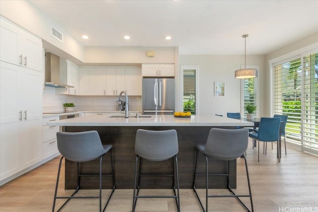 520 Lunalilo Home Rd Unit 354, Honolulu, HI 96825 - kitchen with stainless steel refrigerator, wall chimney range hood, a breakfast bar area, light countertops, and recessed lighting