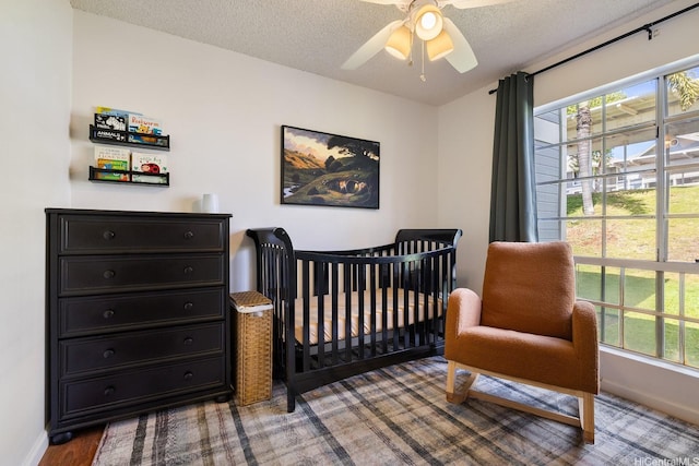 92-1005 Nou St Unit 5103, Kapolei, HI 96707 - bedroom featuring multiple windows, ceiling fan, a textured ceiling, and a crib