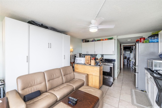 2211 Ala Wai Blvd Unit 3201, Honolulu, HI 96815 - kitchen with appliances with stainless steel finishes, a ceiling fan, light tile patterned floors, a textured ceiling, and dark countertops