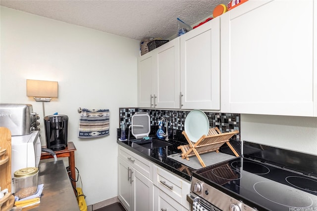 2211 Ala Wai Blvd Unit 3201, Honolulu, HI 96815 - kitchen with stainless steel electric range, white cabinets, tasteful backsplash, and a textured ceiling