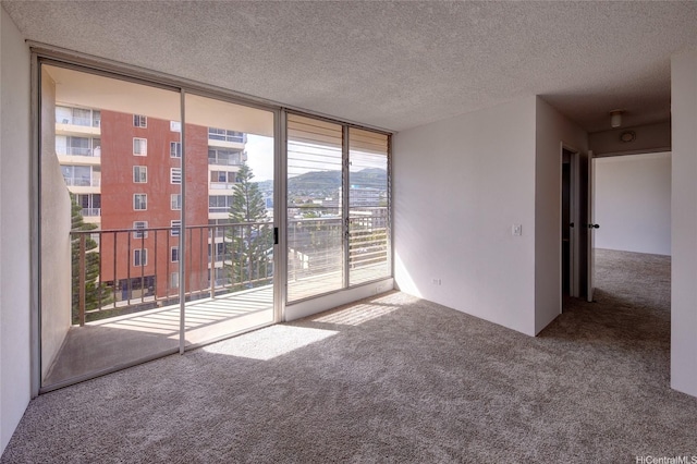 2754 Kuilei St Unit 702, Honolulu, HI 96826 - unfurnished room with carpet floors, a wall of windows, and a textured ceiling