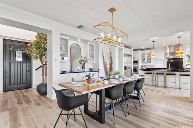 91-1298 Kuanoo St, Ewa Beach, HI 96706 - dining room featuring ornamental molding, light wood finished floors, a chandelier, recessed lighting, and built in shelves