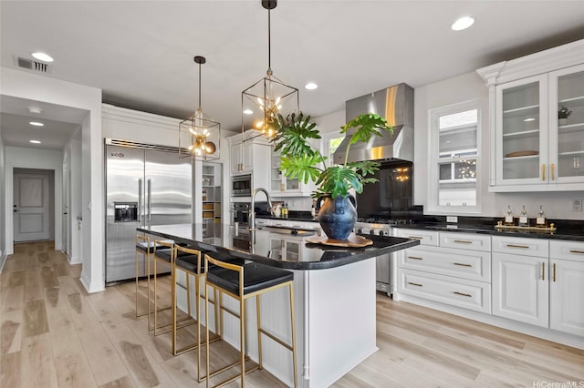91-1298 Kuanoo St, Ewa Beach, HI 96706 - kitchen with appliances with stainless steel finishes, ventilation hood, light wood finished floors, white cabinetry, and recessed lighting