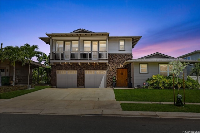91-1298 Kuanoo St, Ewa Beach, HI 96706 - front of property featuring stone siding, driveway, a garage, a front lawn, and a balcony