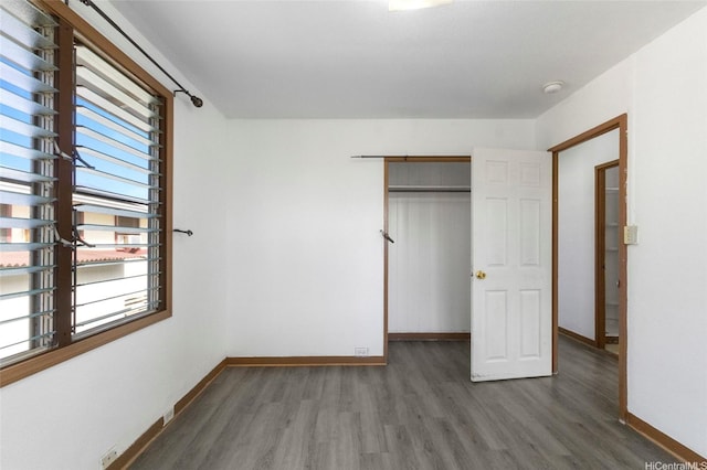 84-570 Farrington Hwy Unit D, Waianae, HI 96792 - unfurnished bedroom with wood finished floors, multiple windows, and a closet