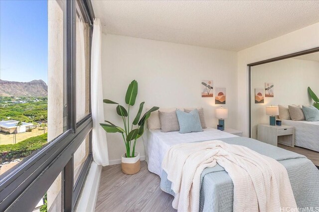 300 Wai Nani Way Unit 1715, Honolulu, HI 96815 - bedroom featuring wood finished floors, a mountain view, and a textured ceiling