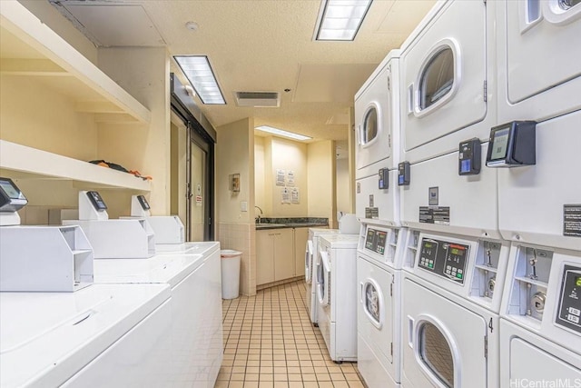 300 Wai Nani Way Unit 1715, Honolulu, HI 96815 - community laundry room featuring washing machine and dryer, stacked washer and clothes dryer, and light tile patterned flooring