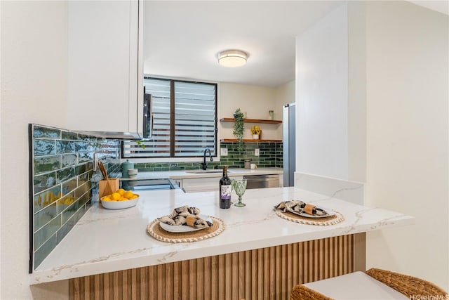 333 Aoloa St Unit 214, Kailua, HI 96734 - kitchen with light stone countertops, open shelves, a peninsula, and dishwasher