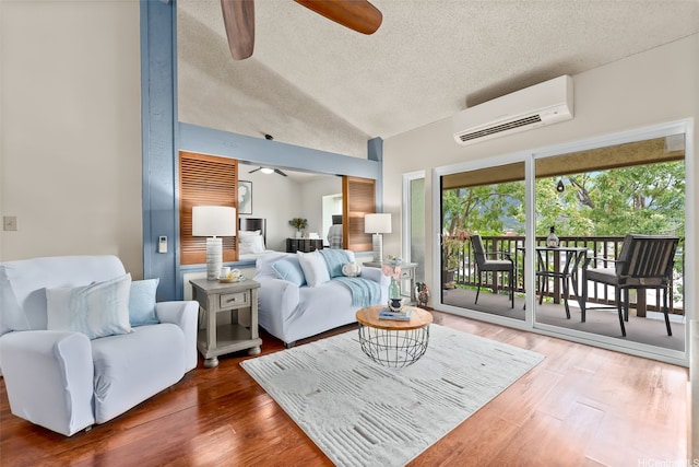 46-036 Aliikane Pl Unit 522, Kaneohe, HI 96744 - living area with ceiling fan, an AC wall unit, wood finished floors, vaulted ceiling, and a textured ceiling