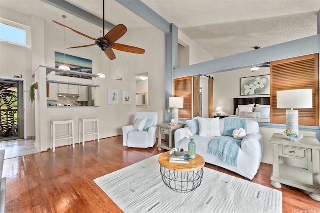 46-036 Aliikane Pl Unit 522, Kaneohe, HI 96744 - living area with a ceiling fan, high vaulted ceiling, wood finished floors, and a textured ceiling