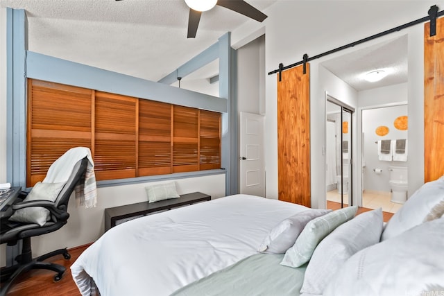 46-036 Aliikane Pl Unit 522, Kaneohe, HI 96744 - bedroom featuring a barn door, a textured ceiling, ceiling fan, ensuite bathroom, and wood finished floors