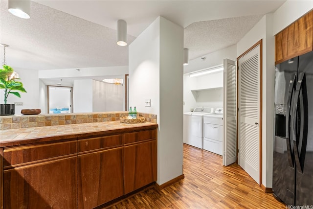 1525 Wilder Ave Unit 401, Honolulu, HI 96822 - kitchen with black fridge with ice dispenser, light wood finished floors, a textured ceiling, tile countertops, and brown cabinetry