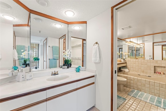 1525 Wilder Ave Unit 401, Honolulu, HI 96822 - bathroom with a textured ceiling, tiled tub, vanity, and tile patterned flooring