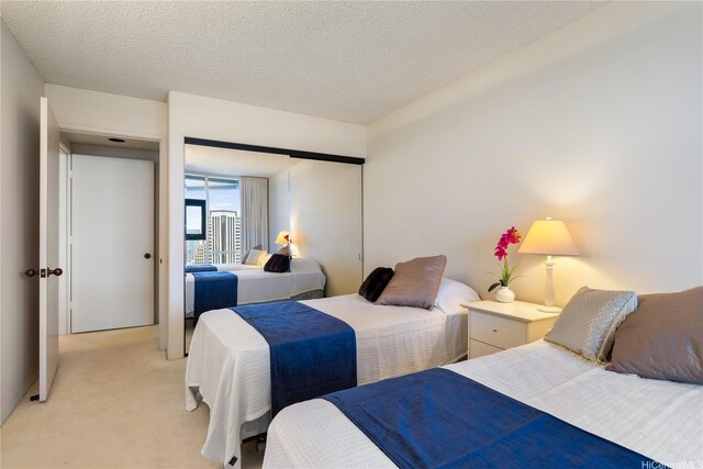 1212 Nuuanu Ave Unit 3402, Honolulu, HI 96817 - bedroom featuring light colored carpet, a closet, and a textured ceiling
