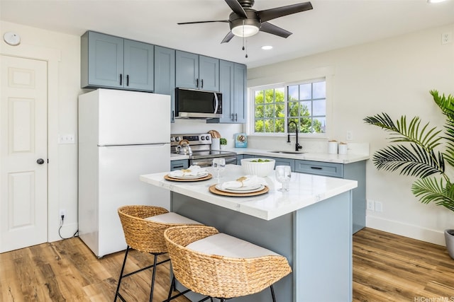 54-290 Kawaipuna Pl, Hauula, HI 96717 - kitchen featuring stainless steel appliances, a kitchen bar, a ceiling fan, light wood-type flooring, and recessed lighting