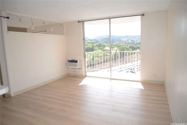98-1038 Moanalua Rd Unit 7-1706, Aiea, HI 96701 - empty room featuring floor to ceiling windows, light wood finished floors, rail lighting, and a wall unit AC