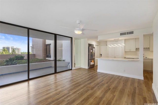 1910 Ala Moana Blvd Unit 7D, Honolulu, HI 96815 - unfurnished living room featuring wood finished floors, ceiling fan, and floor to ceiling windows