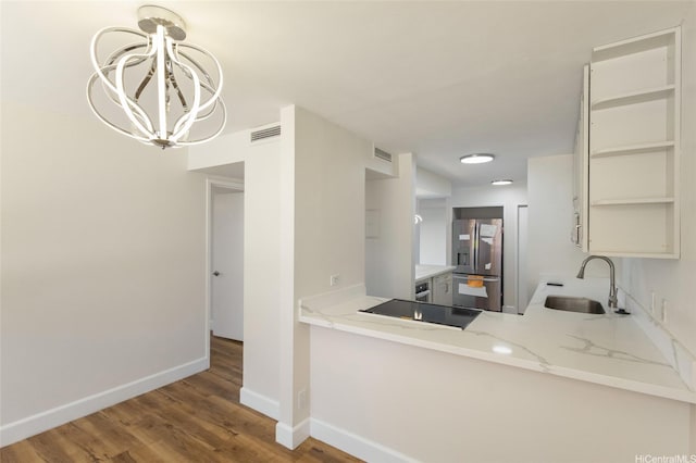 1910 Ala Moana Blvd Unit 7D, Honolulu, HI 96815 - kitchen with stainless steel fridge, black electric cooktop, a chandelier, wood finished floors, and light stone counters