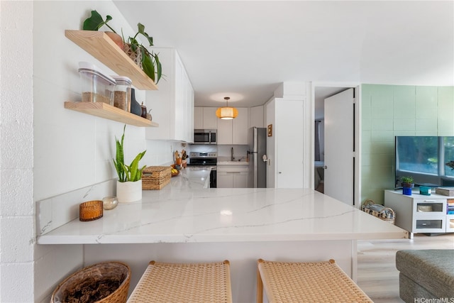 920 Kaheka St Unit 25, Honolulu, HI 96814 - kitchen featuring open shelves, stainless steel appliances, a peninsula, light stone countertops, and a breakfast bar