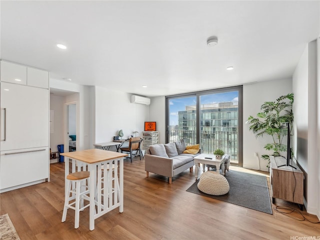 987 Queen St Unit 4112, Honolulu, HI 96814 - living area with a wall unit AC, light wood finished floors, a wall of windows, and recessed lighting