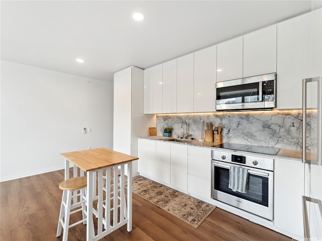 987 Queen St Unit 4112, Honolulu, HI 96814 - kitchen featuring stainless steel appliances, dark wood-style flooring, tasteful backsplash, white cabinets, and modern cabinets